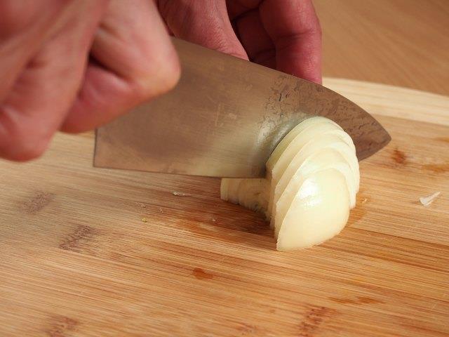 Zwiebeln für Fajitas in Scheiben schneiden Zwiebeln für Fajitas in Scheiben schneiden